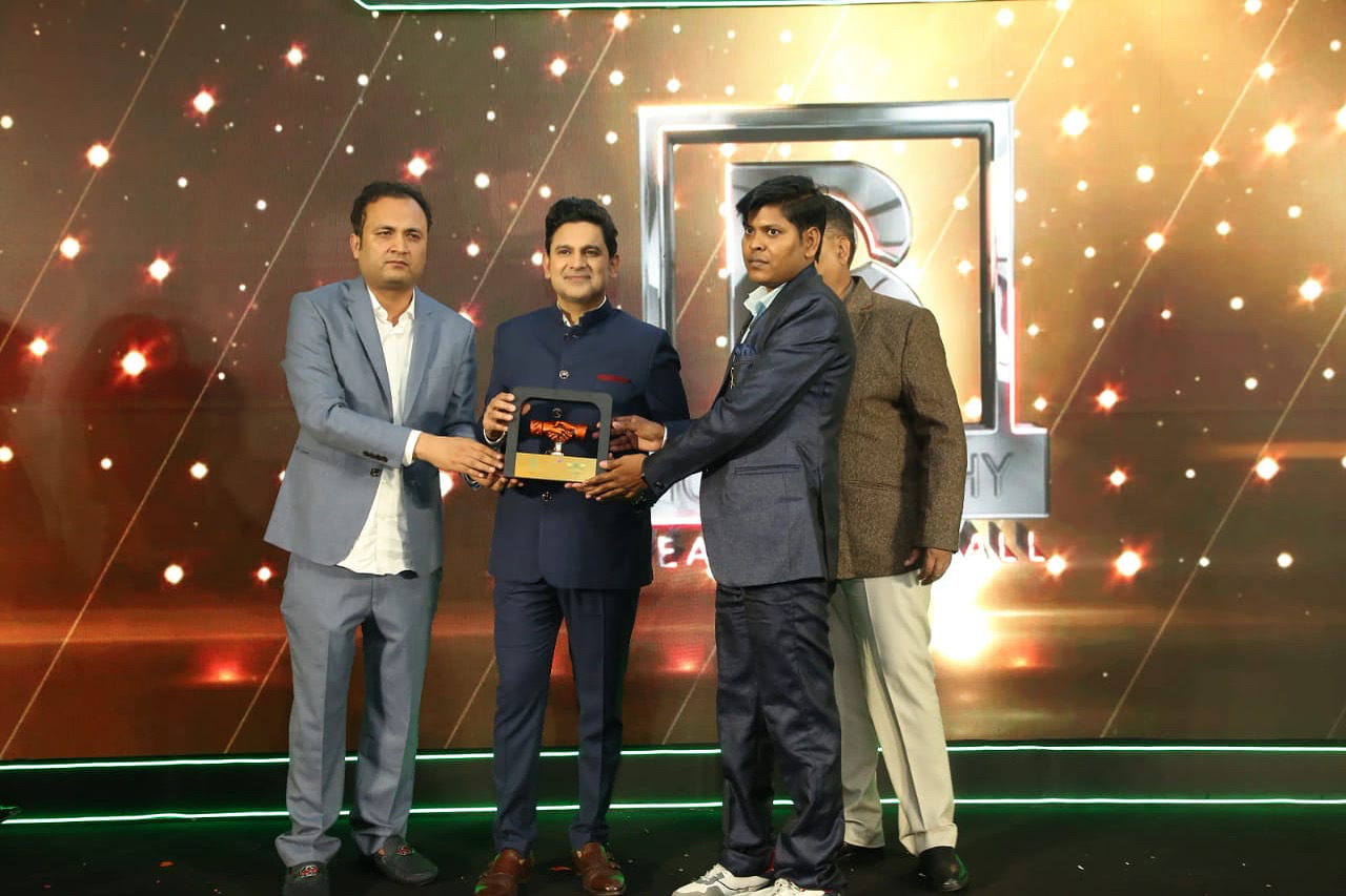 Dr. Santosh Kumar Verma receiving a memento on stage at an awards ceremony